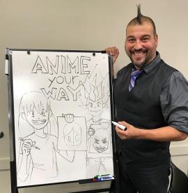 Presenter Carlos Niento III next to a whiteboard with some of his anime-style drawings.
