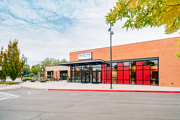 A modern brick building with red window accents, labeled 