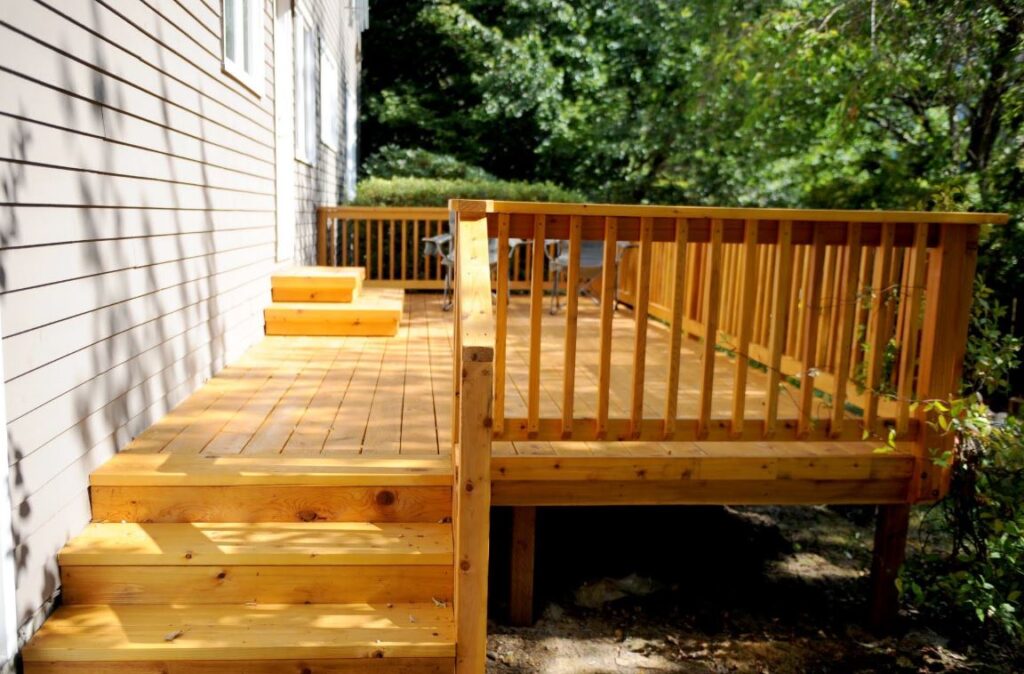 Cedar deck in the backyard with a wooded background. 