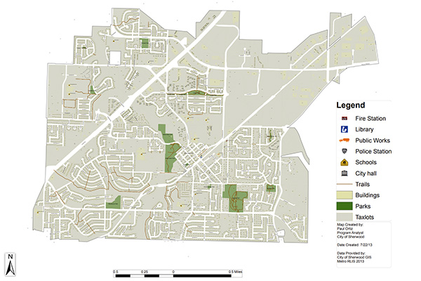 Map of a city showing locations of fire stations, libraries, public works, police stations, city hall, schools, trails, buildings, parks, and taxlots, with a legend for symbols.