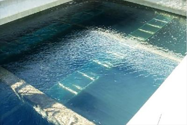 A swimming pool with clear water, revealing submerged steps and lanes beneath the surface.