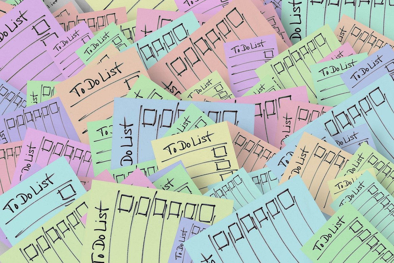 A pile of colorful to-do list notes, each with checkboxes and "To Do List" written at the top, scattered in an overlapping arrangement.
