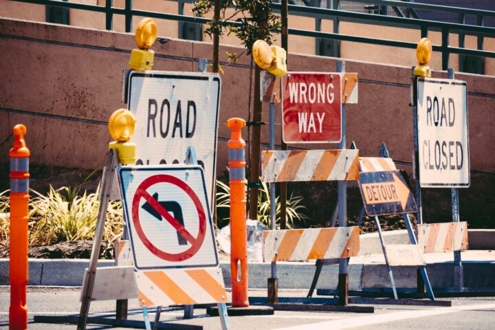 Multiple road signs and barricades, including 